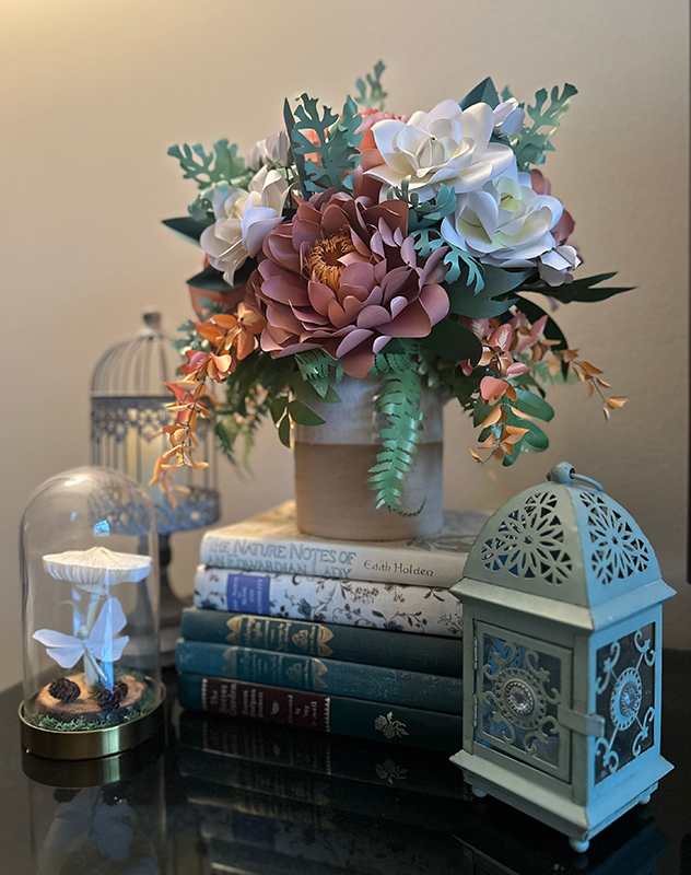 stillLife Still life of flowers books, and a cloche.