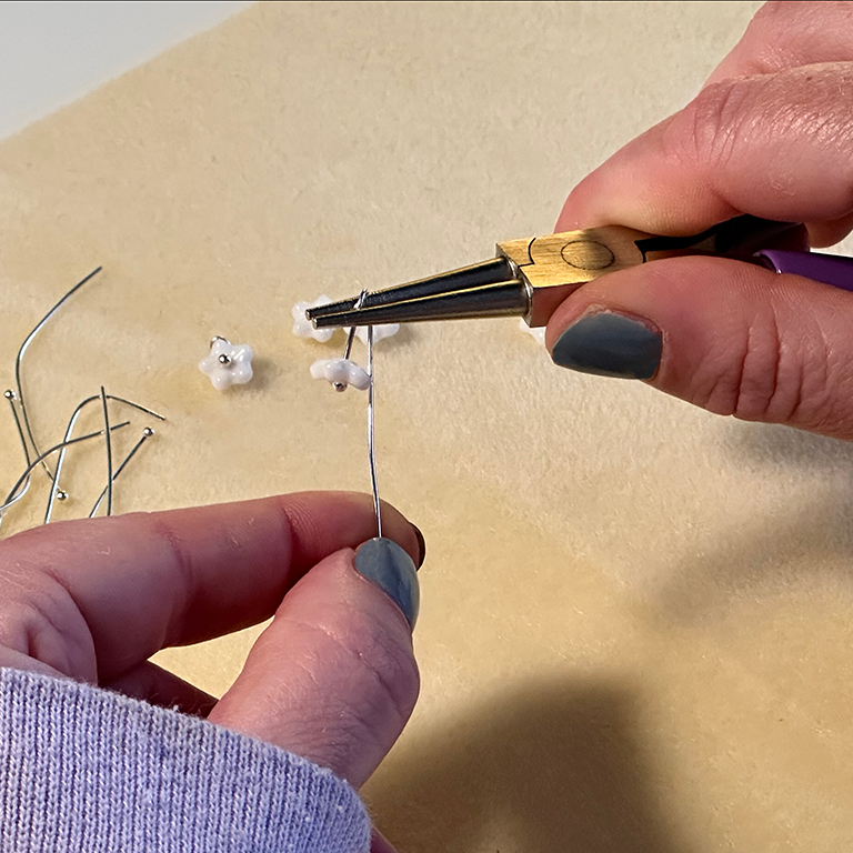 headpin being formed into an earring with pliers.